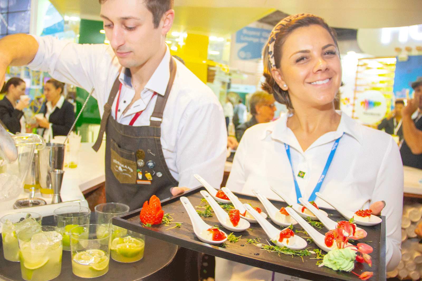 Catering staff plating canapés behind a counter at a corporate event.