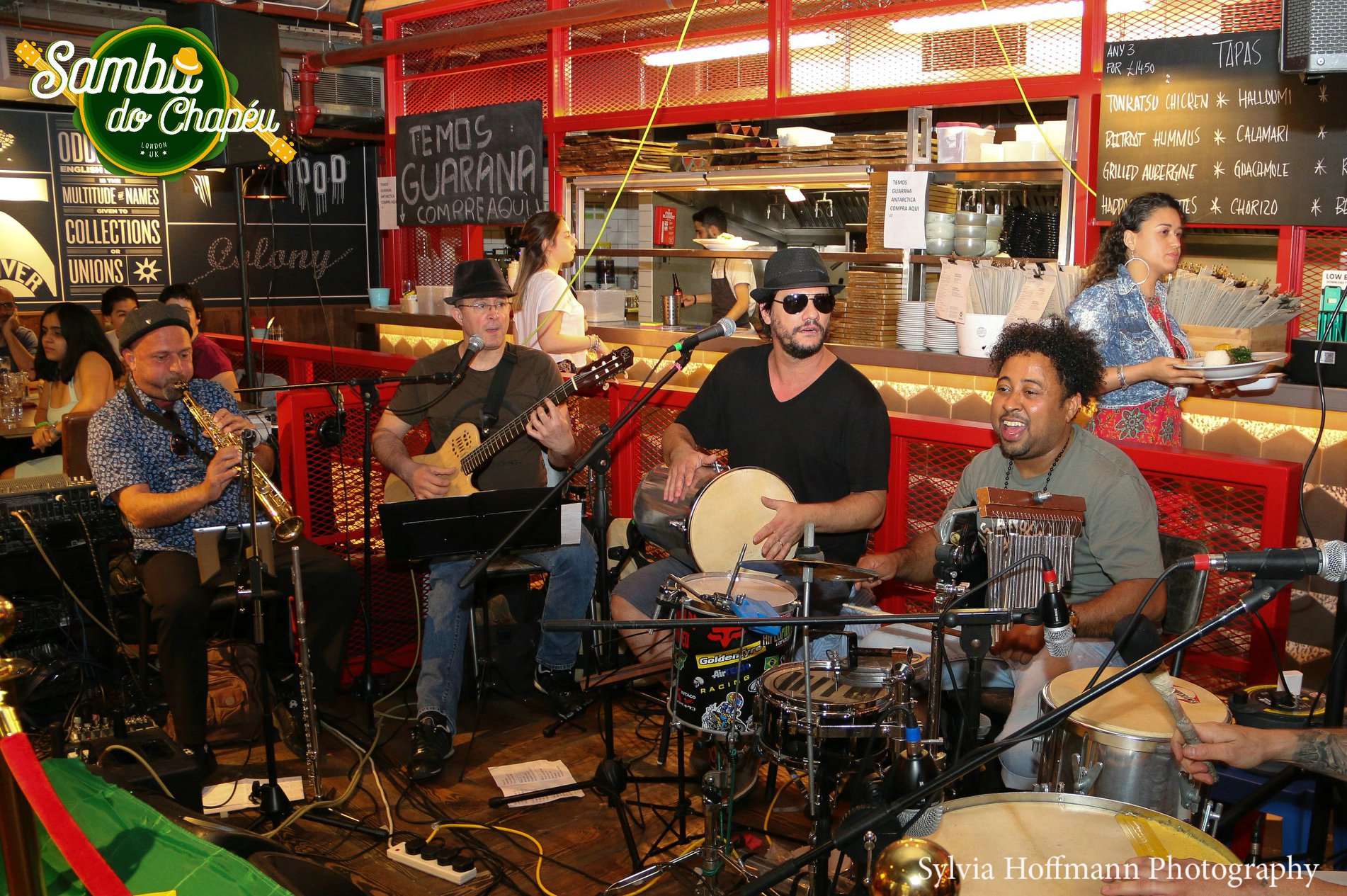 A band playing live to a full room at the Samba do Chapéu bar.