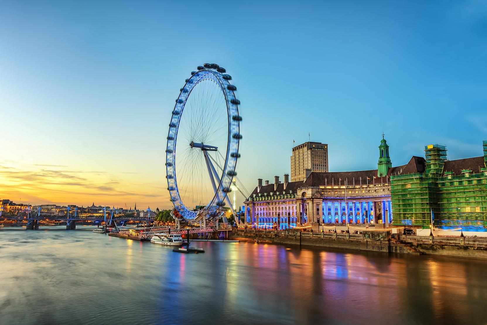 The London Eye and the South Bank reflected in the Thames at sunset.