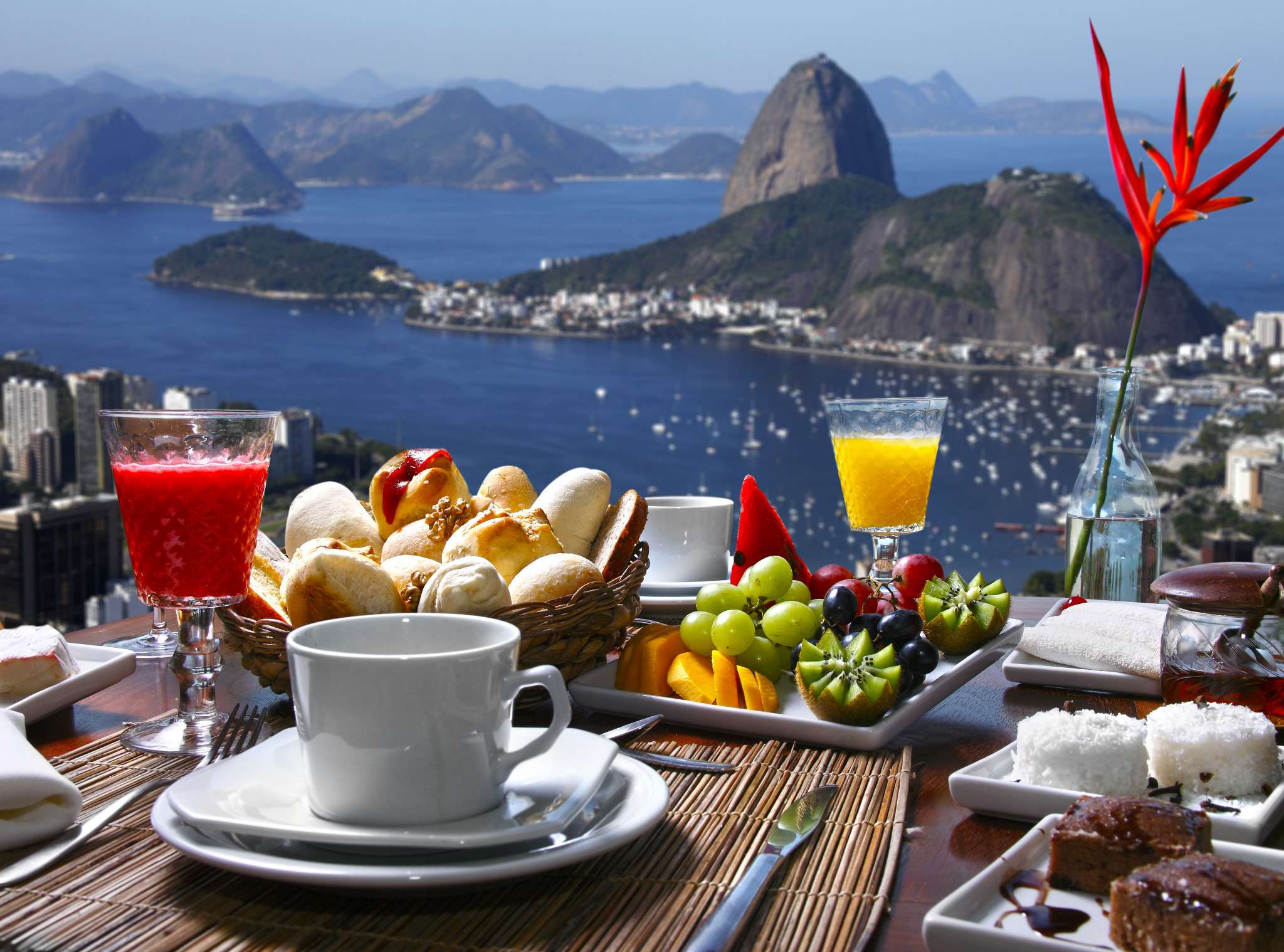 A breakfast table of fruit, pastries and coffee laid out above Guanabara Bay in Rio de Janeiro.